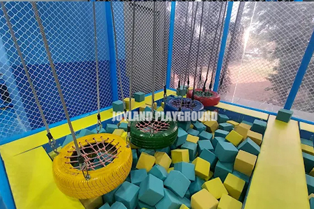 Children jumping into a soft sponge pit in an indoor playground in India.