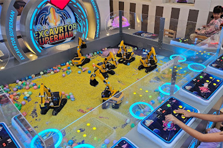Indoor sand play zone with remote-controlled digger in indoor playground equipment for home.