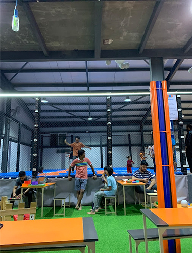 Parent seating area designed into indoor playground layout in India.
